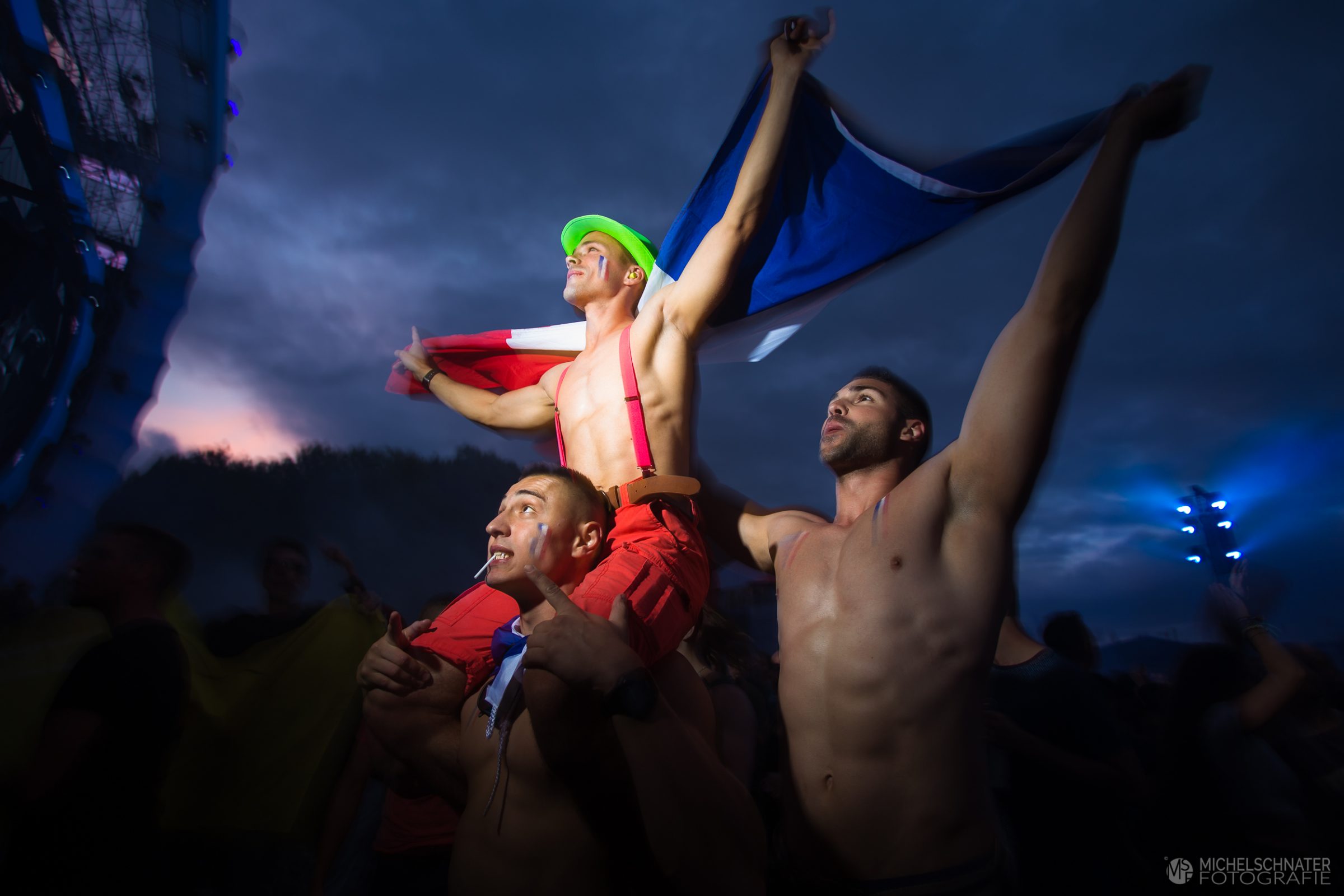 drie mannen met Franse vlag voor het podium dance valley bij avond foto gemaakt door Michel Schnater