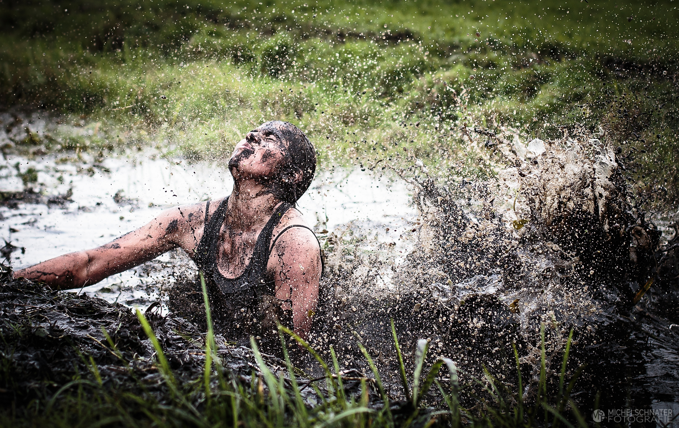 Vrouw die in de modder springt met druppels tijdens polderloop Spaarndam foto gemaakt door Michel Schnater